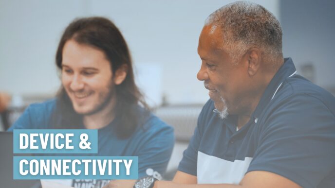 Image of a Digital Navigator supporting a community member at a laptop distribution event.